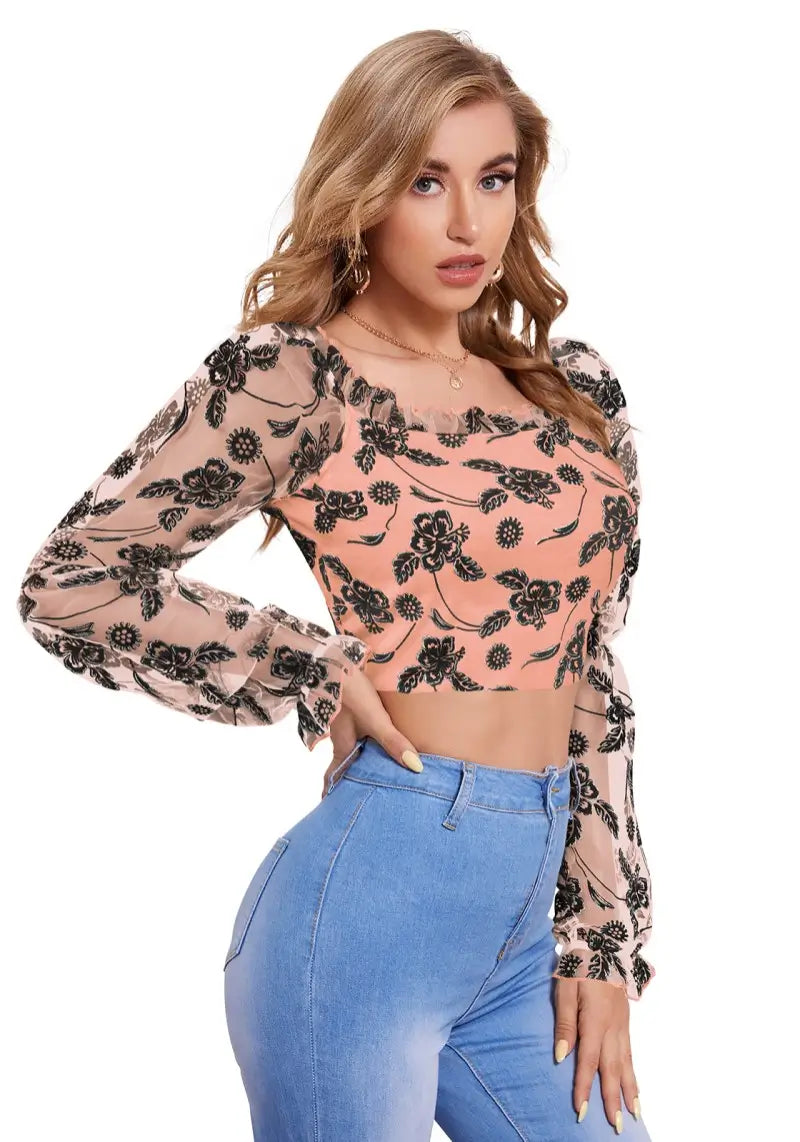 Side profile of model in peach sheer puff sleeve crop top with floral design