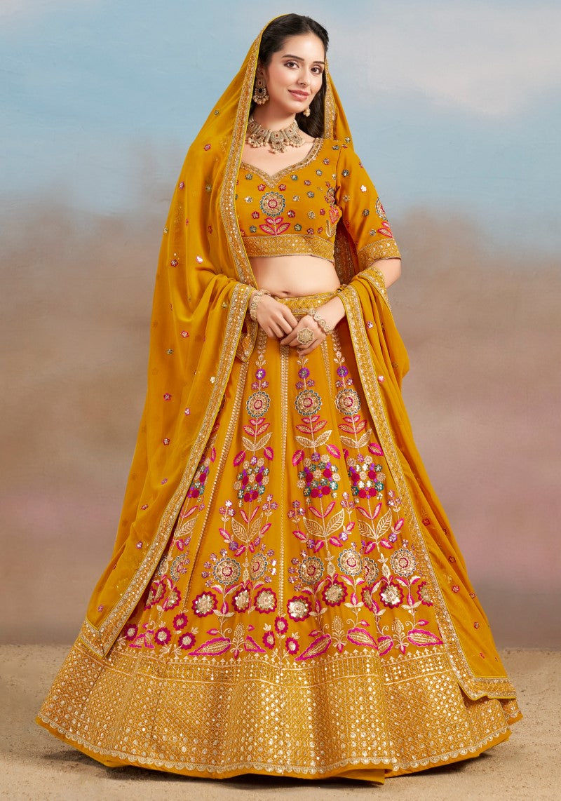 Front view of the model wearing mustard yellow floral zari embroidered lehenga choli with matching georgette dupatta