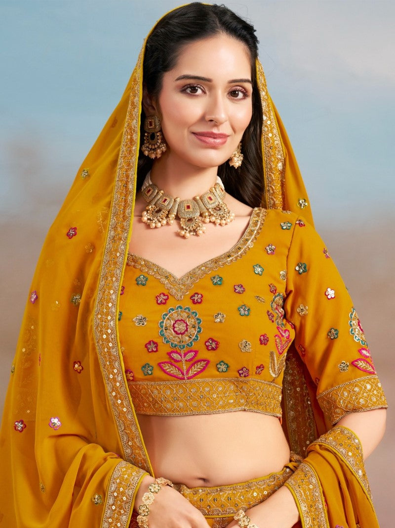 Close-up of floral zari and resham embroidery with sequins on mustard yellow georgette lehenga choli, model showing the choli embellishment