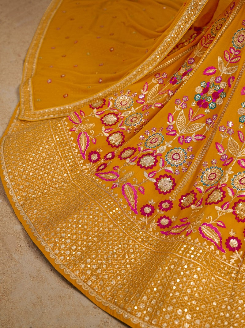 Close-up view of floral zari and resham embroidery with sequins on mustard yellow georgette lehenga