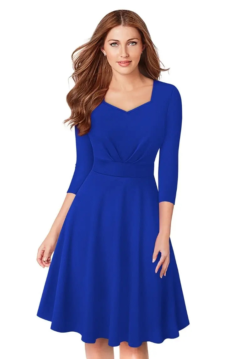 Model wearing Royal Blue Fit & Flare Flounce Hem Dress with diamond neckline and 3/4 sleeves, posing front-facing.