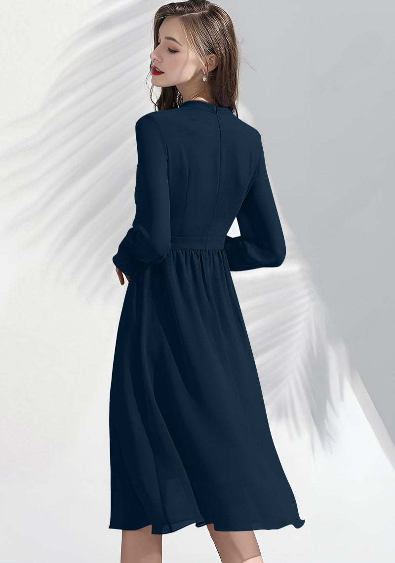 Back view of Morpich midi dress featuring soft pleated hem and elegant flowy silhouette.