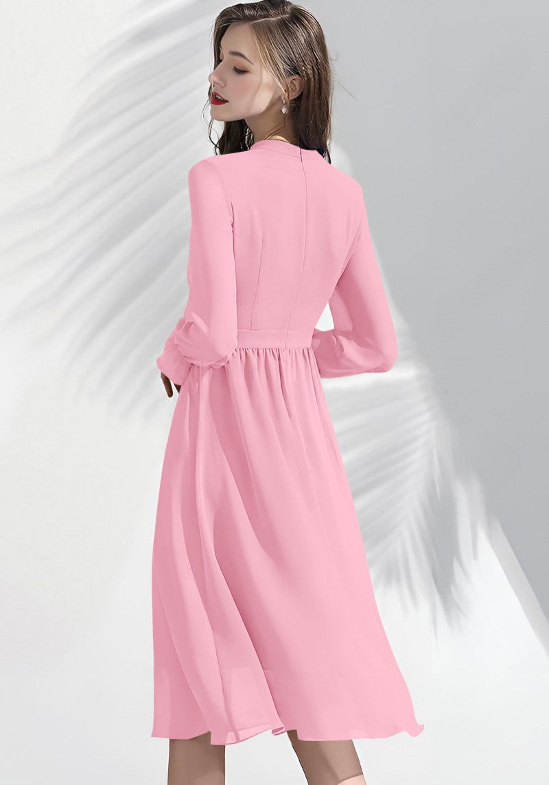Model showing back of Peach ruffle midi dress with defined waist and flared hem.
