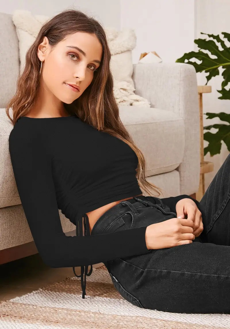 Model lounging in black ruched side drawstring crop top with full sleeves – relaxed chic look