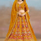 Front view of the model wearing mustard yellow floral zari embroidered lehenga choli with matching georgette dupatta