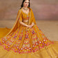 Full Front view of the model in sitting position showcasing mustard yellow floral zari embroidered flared lehenga choli with matching georgette dupatta 