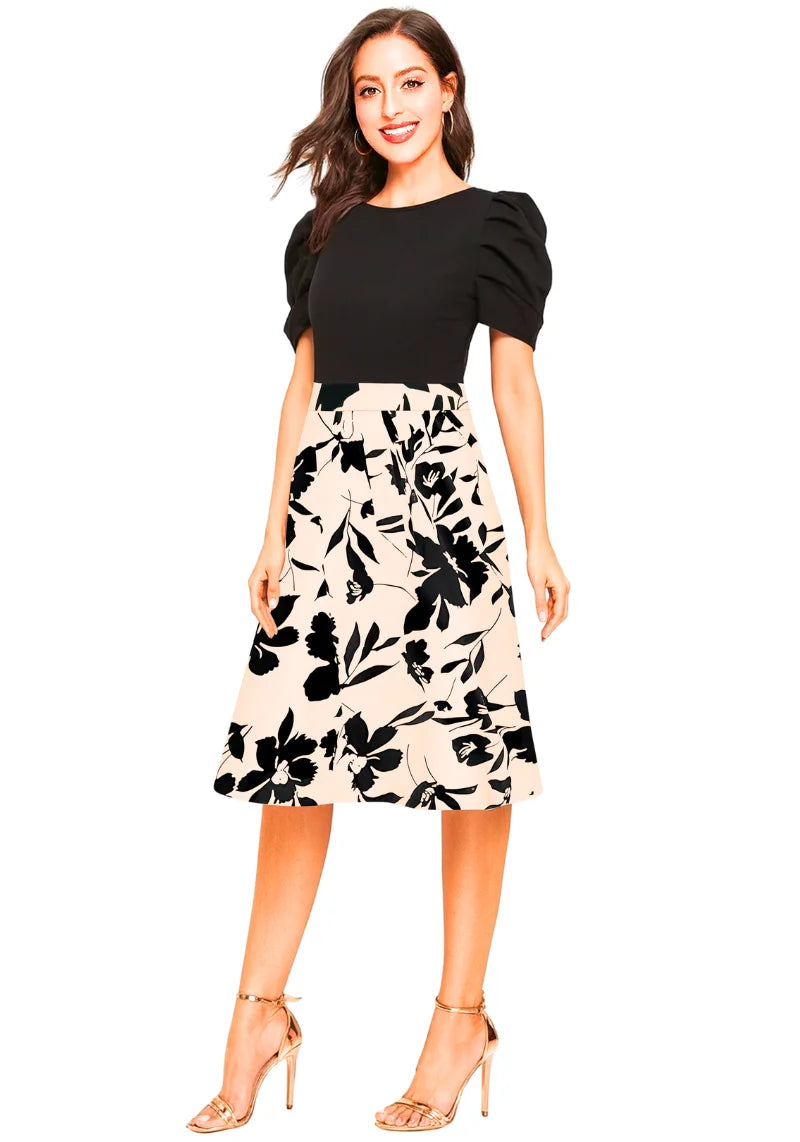 Woman wearing a black top and floral skirt on a white background