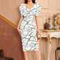 Front view of the model wearing  White Geometric Printed Puff Sleeves Top and Skirt Set featurig catchy geometric print in black and with a sweetheart neckline, paired with a below-knee length skirt with a back slit.